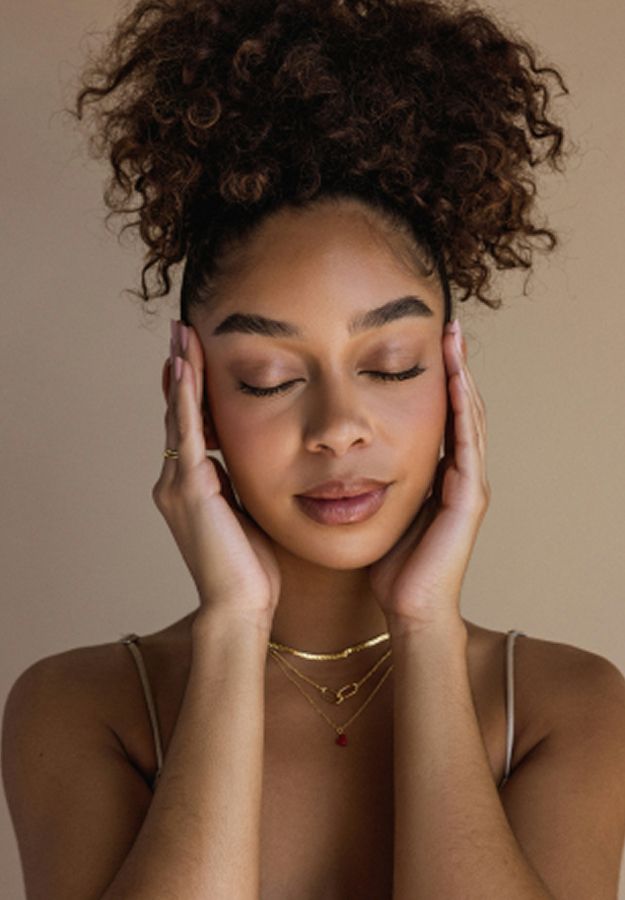 med spa patient model with closed eyes holding her face gently.