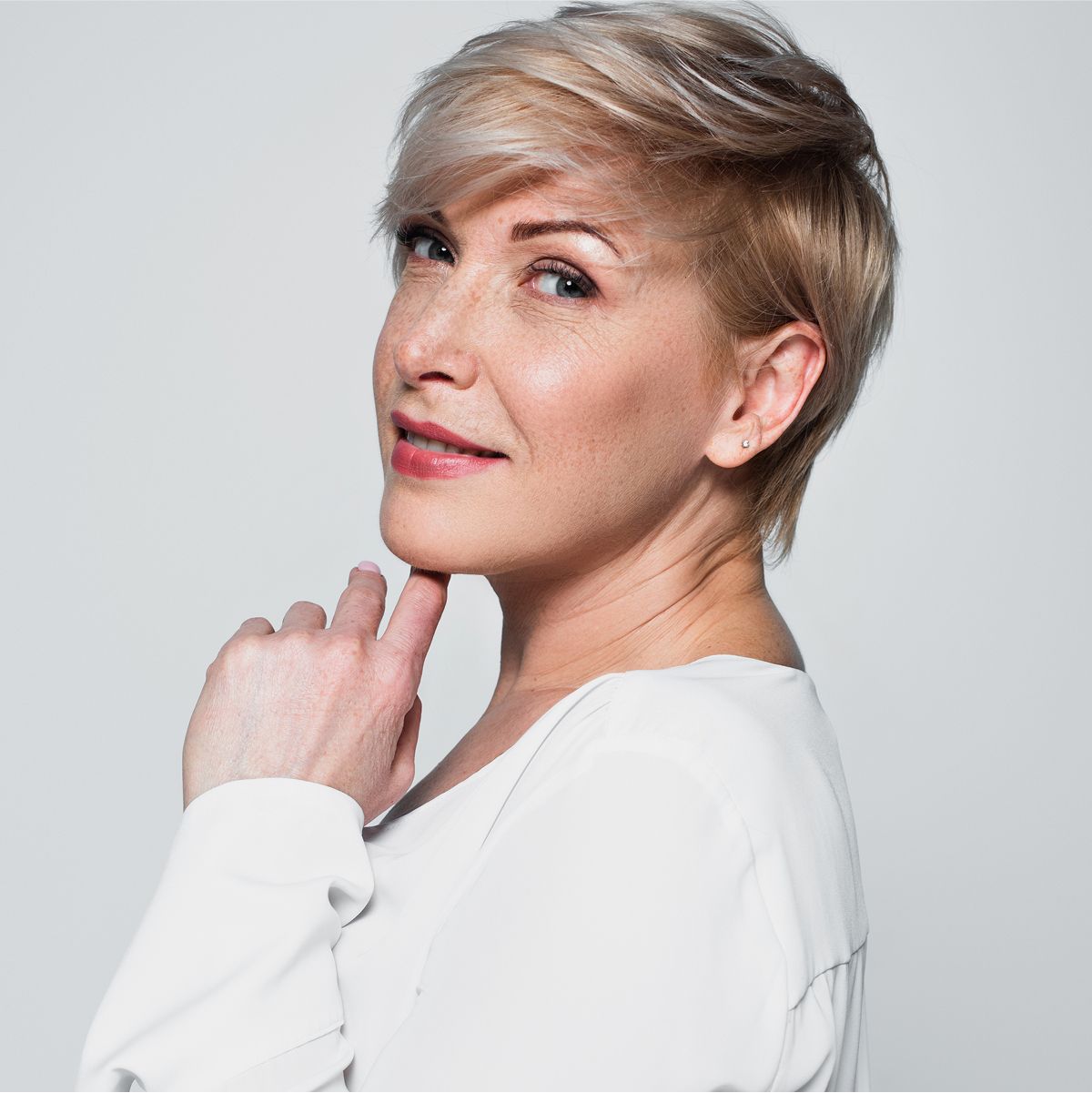 med spa patient model with stylish short hair, smiling softly.