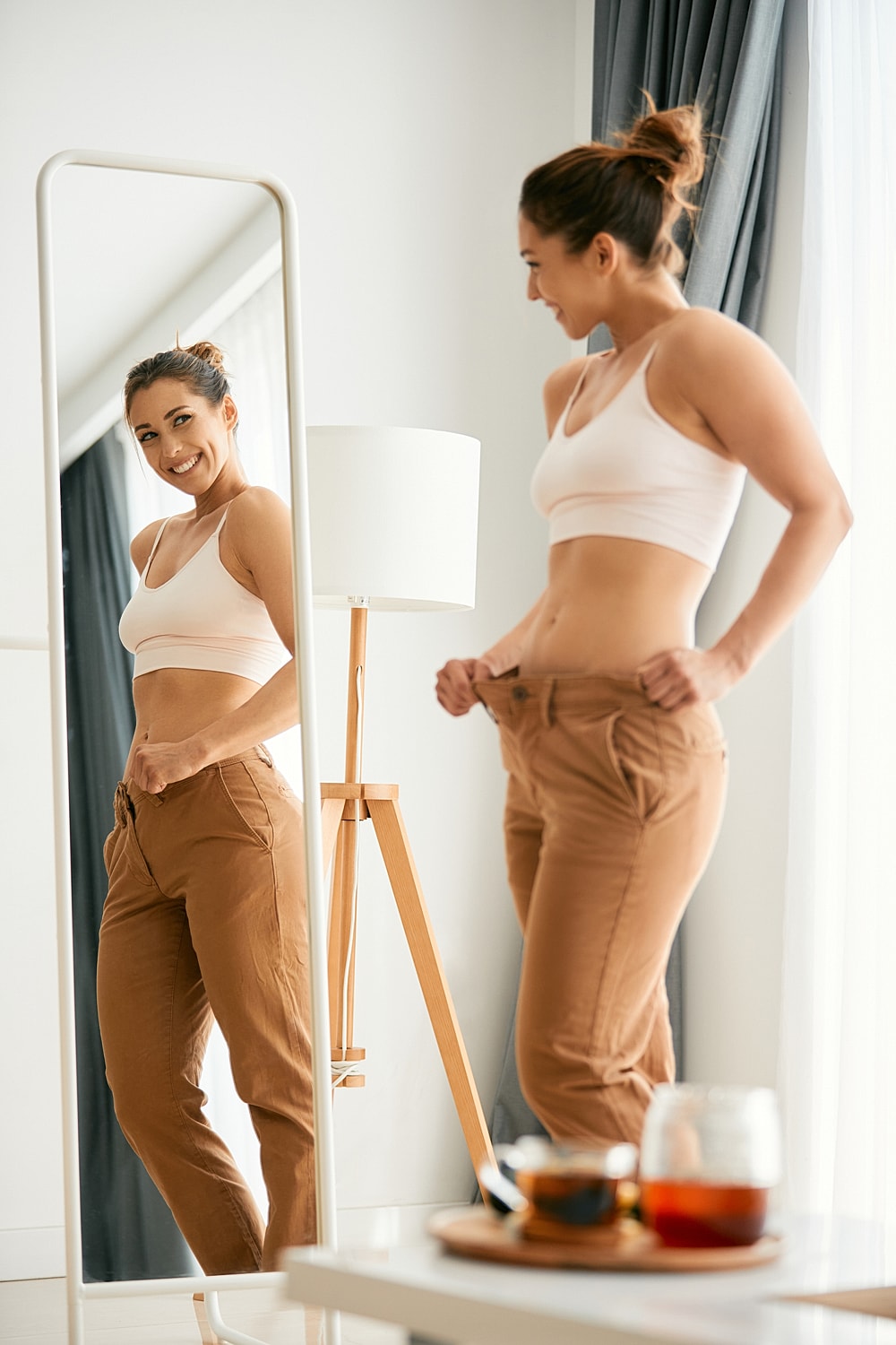 retatrutide patient model smiling at her reflection in a mirror.