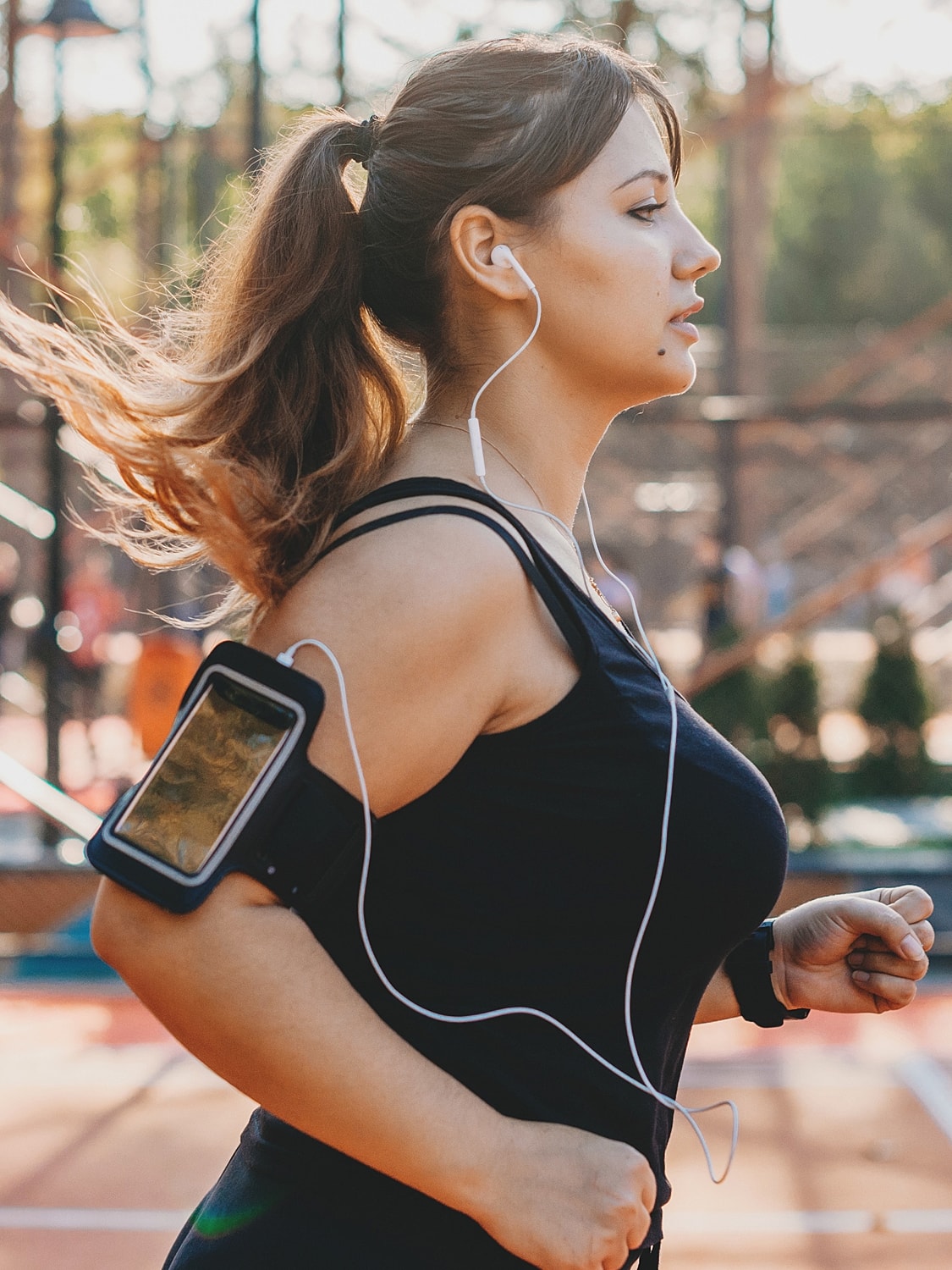 medical weight loss patient model jogging with headphones and smartphone holder.