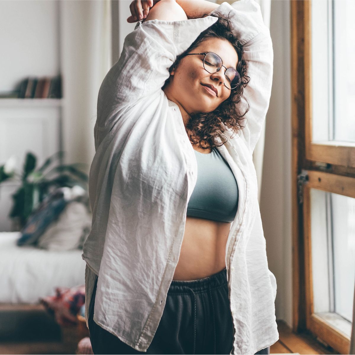 medical weight loss patient model stretching in a bright, cozy room.