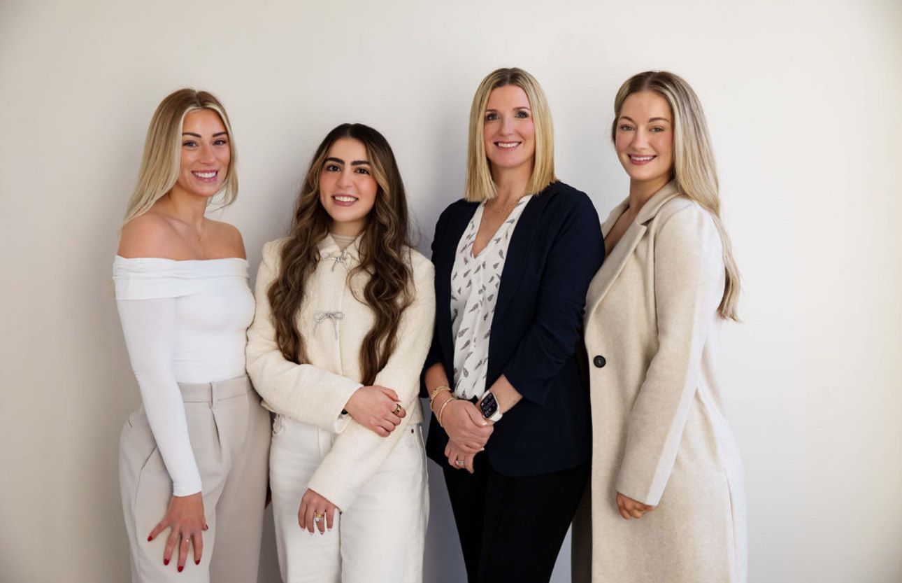 Group of four women posing together indoors.