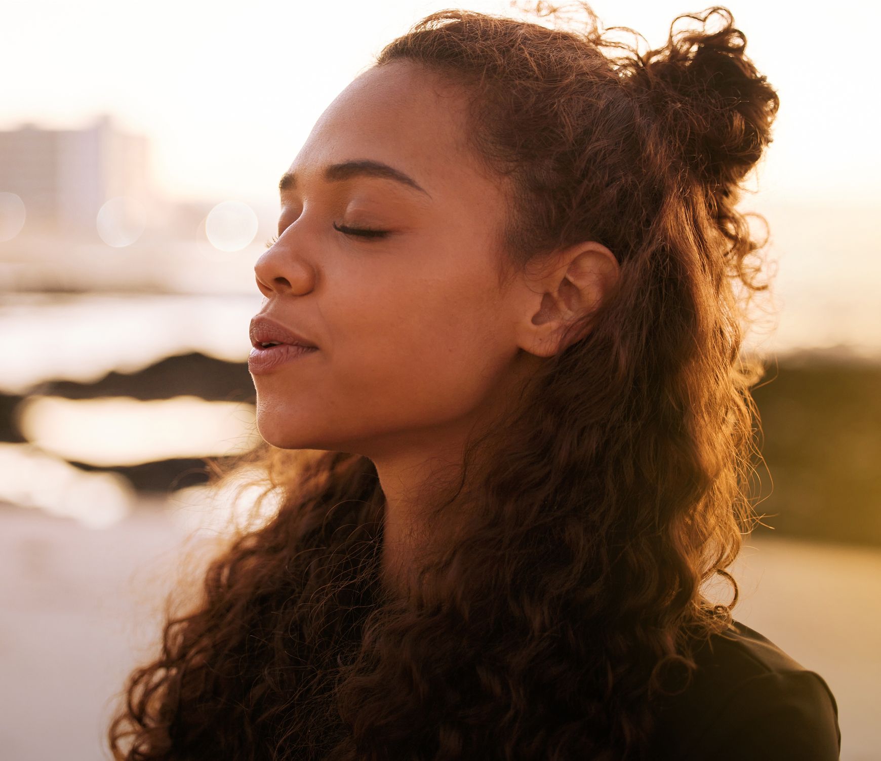 med spa patient model with curly hair, eyes closed, serene expression.