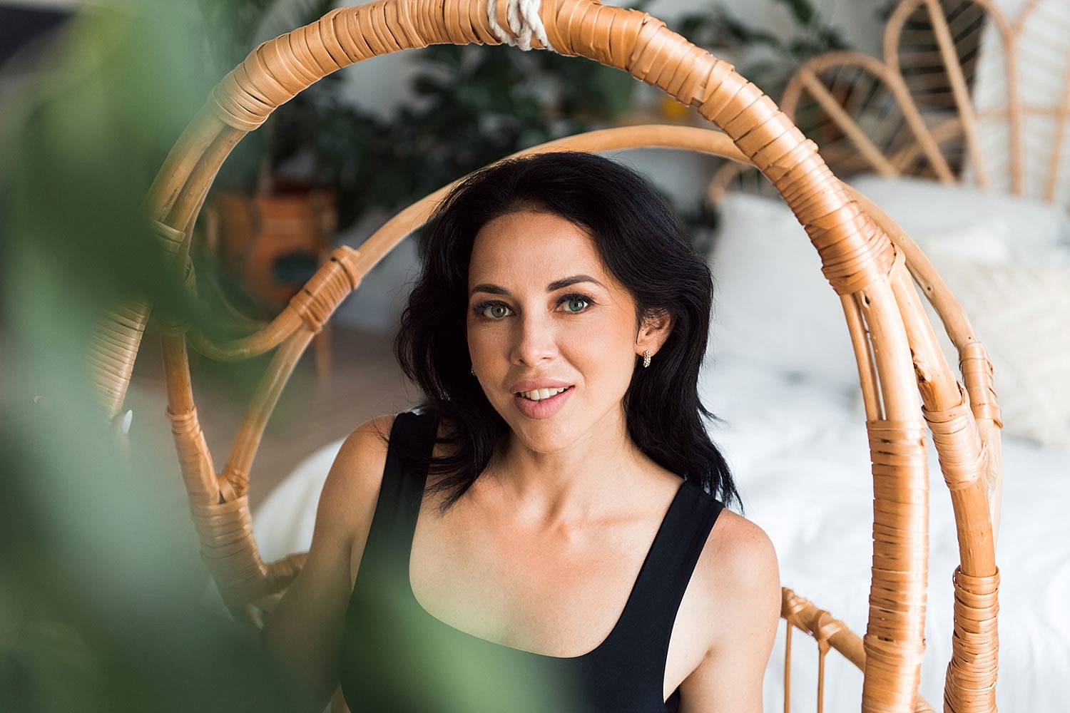 Woman sitting in a rattan chair indoors.