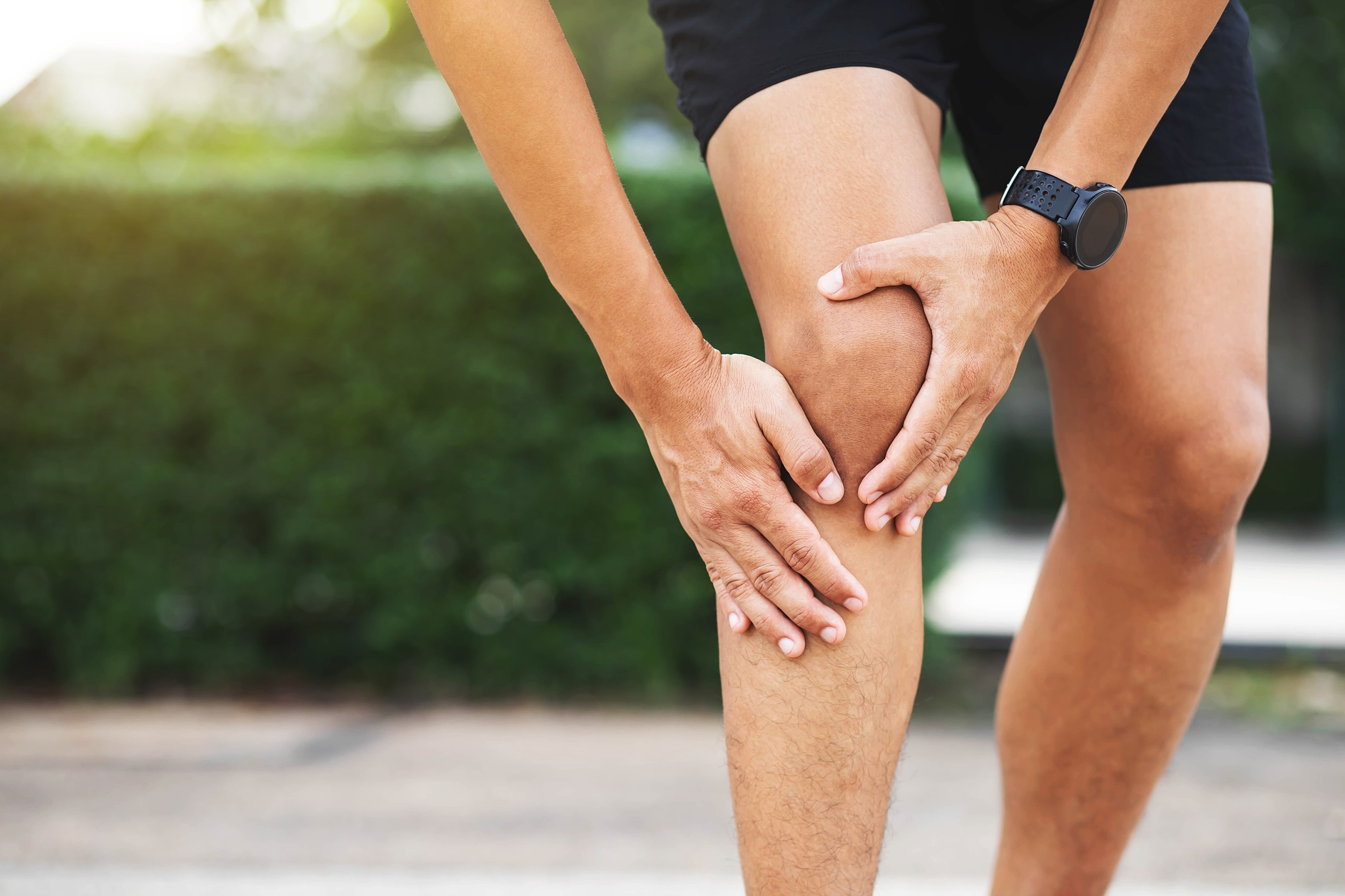 Person holding knee, experiencing discomfort or pain.