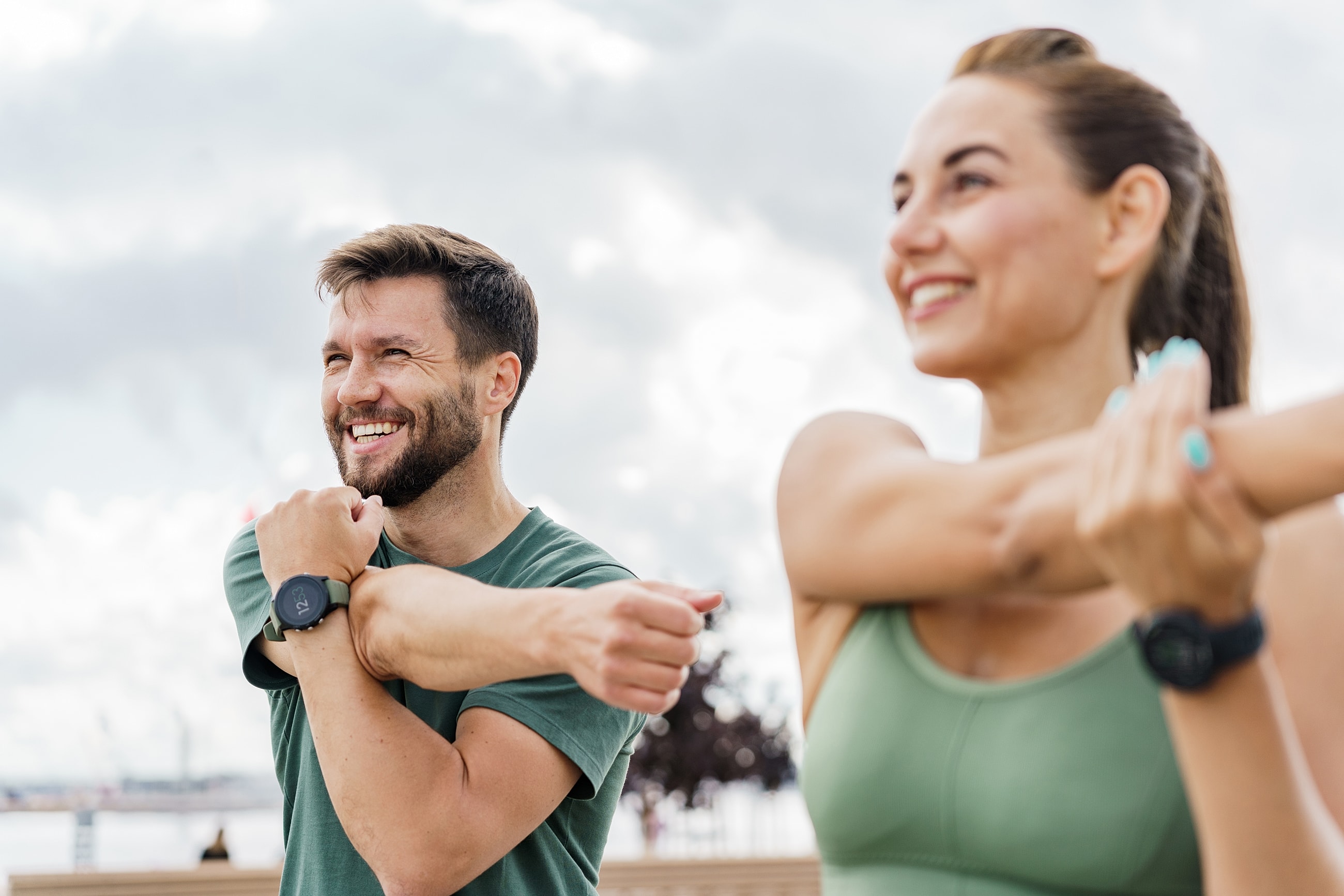 Cheerful couple stretching outdoors together.