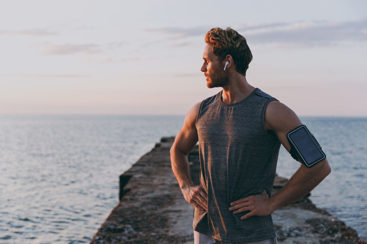 mens health patient model exercising by the ocean at sunset.