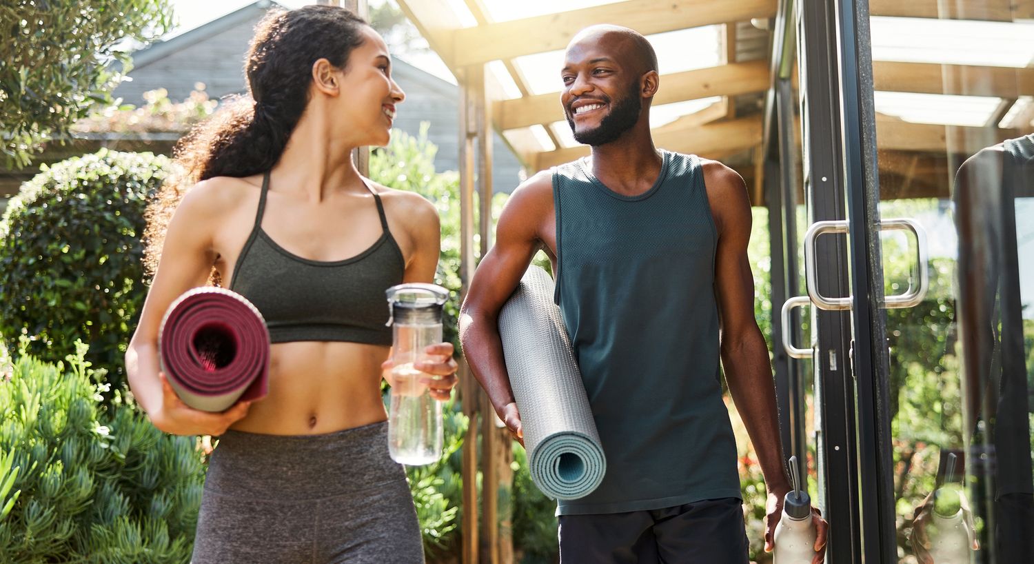 longevity medicine patient models walking outdoors with yoga mats and water.